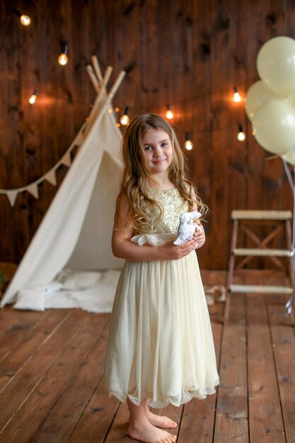 a girl in a yellow dress portrait, with a toy rabbit, easter theme