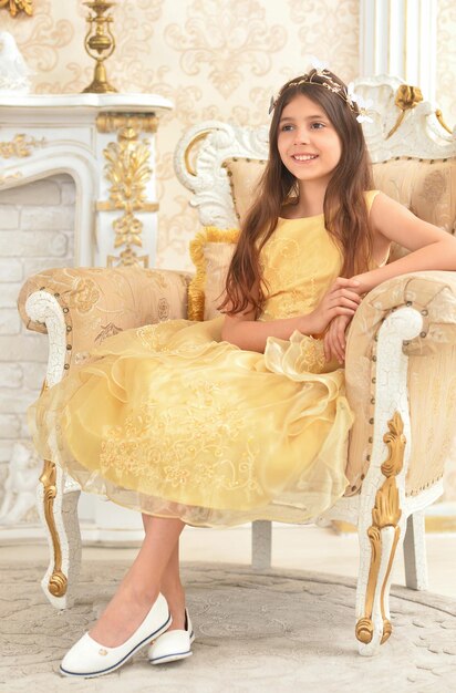 Photo girl in yellow dress sitting in armchair