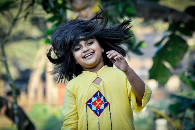 Photo a girl in a yellow dress smiles and dances.