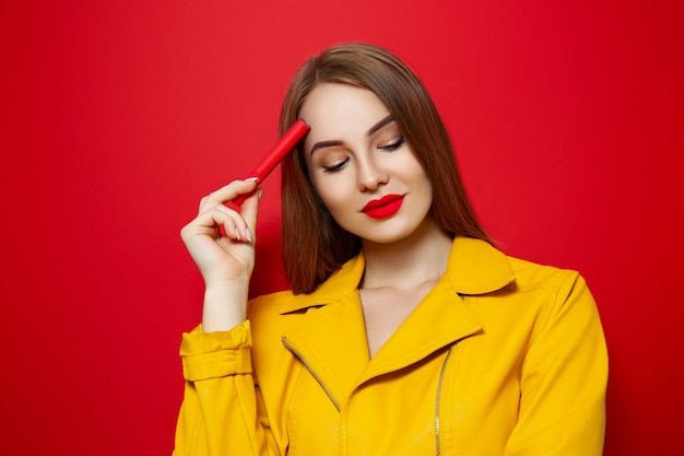 Girl in a yellow jacket on a red background