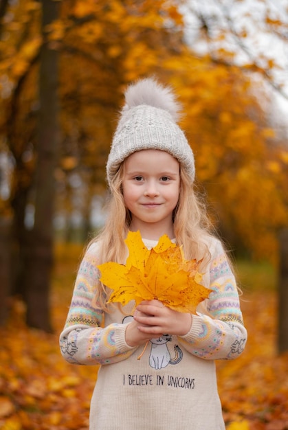 a girl in yellow leaves nature a happy child