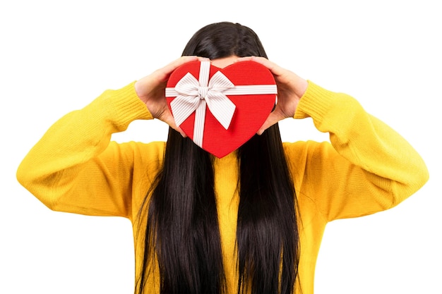 Girl in a yellow sweater with a gift in the form of a heart isolated on white background
