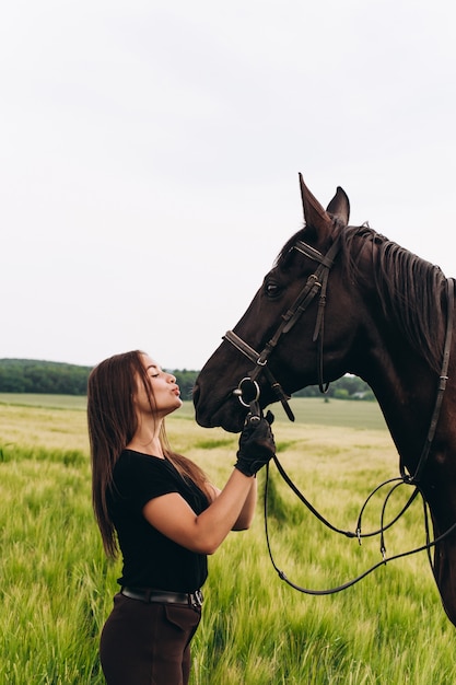 A girl and a young sports horse in the nature