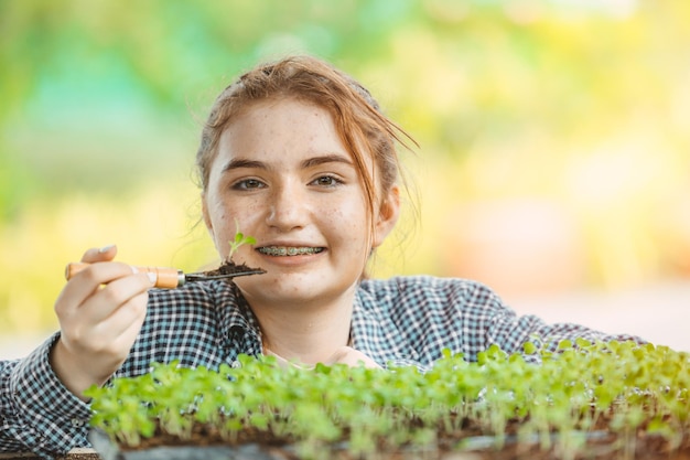 Girl young teen growing plant tree in the garden cute lovely