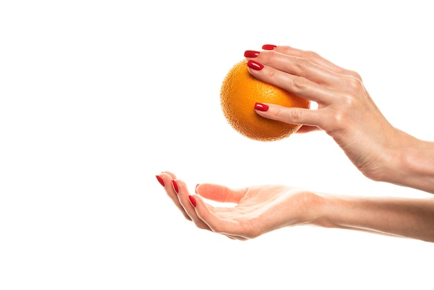 The girl39s hand holds a cut round slice of fresh tropical orange An orange in a woman39s hand on a white background is isolated Orange slice The girl gently holds a citrus in hand