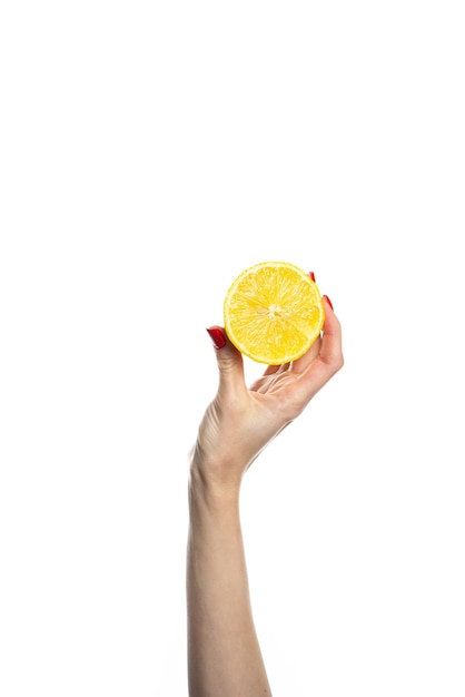 소녀의 손에는 신선한 열대 오렌지의 잘린 둥근 조각이 있습니다. 흰색 배경에 있는 여성의 손에 있는 오렌지가 격리되어 있습니다. 오렌지 조각 소녀는 부드럽게 감귤류를 손에 쥐고 있습니다.