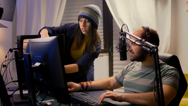 Girlfriend supports her pro gamer boyfriend, playing online video game using streaming professional equipment