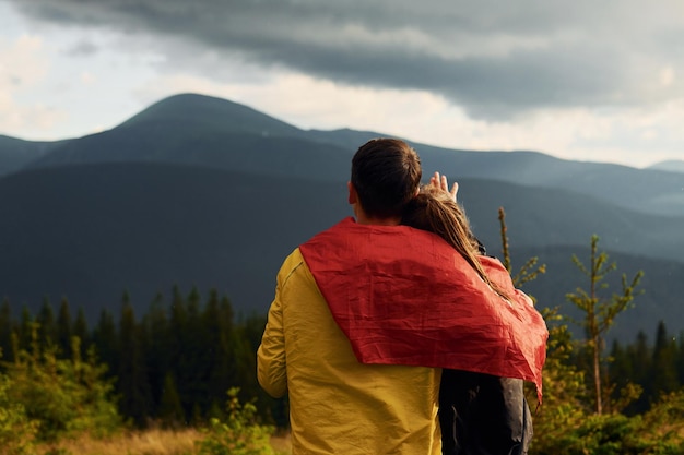 Photo girlfriend with her boyfriend embracing each other majestic carpathian mountains beautiful landscape of untouched nature