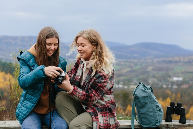 Girlfriends are resting on a bench in the mountains