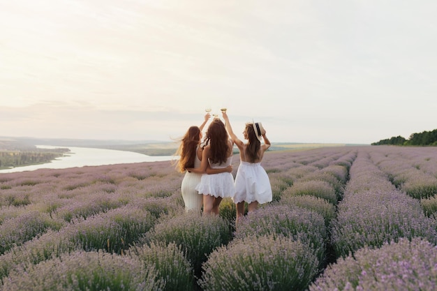 girlfriends raise a toast with glasses of white wine on a sunset