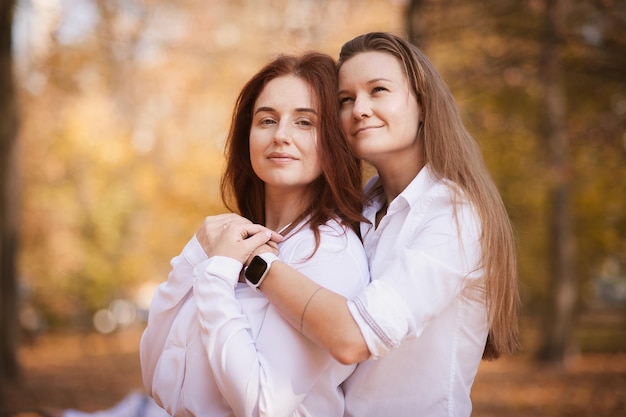 Girlfriends with children in the park in autumn