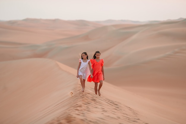 Photo girls among dunes in rub al-khali desert in united arab emirates