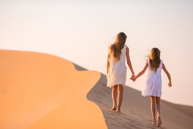 Ragazze tra le dune nel deserto di rub al-khali negli emirati arabi uniti