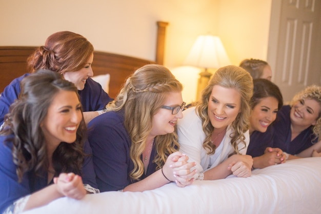 Girls best friends laughing on bed