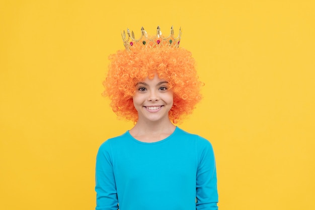 Girls birthday party. happy funny kid in curly wig and crown. imagine herself a queen. cheerful child wear diadem. teen girl in tiara. being a clown. april fools day. happy childhood.