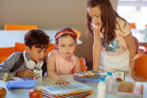 食堂で昼食をとりながらスケジュールをチェックする女の子と男の子