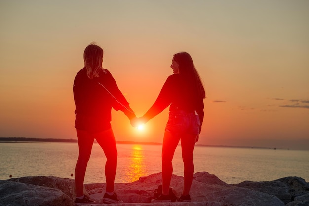 Foto ragazze in riva al mare all'alba