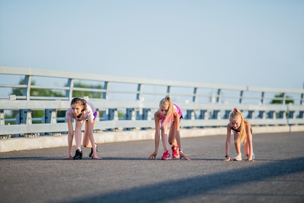 女の子は夕方の空に対してアスファルト道路で競います