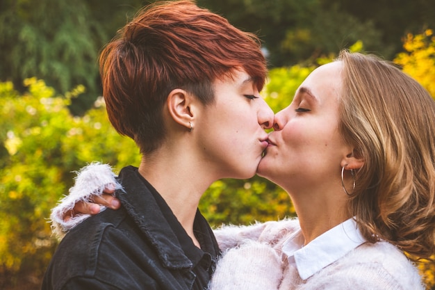 Фото Влюбленная пара девушек обнимает поцелуи в парке