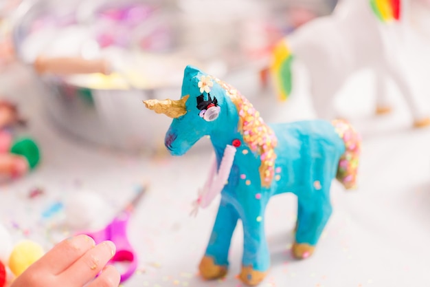 Girls decorating their small paper mache unicorns figurines at the unicorn extravaganza party.