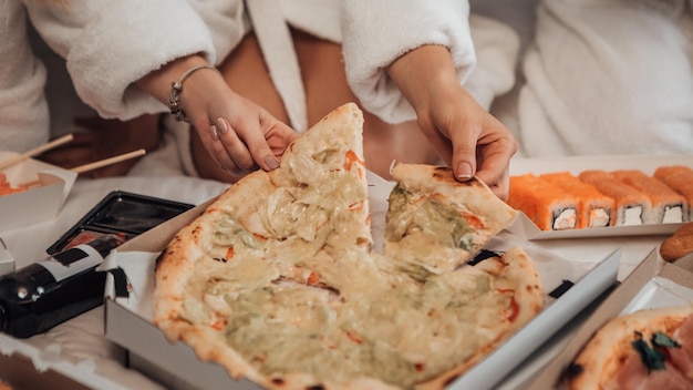 Foto ragazze che mangiano pizza a letto