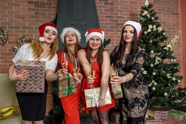 Girls in elegant dresses posing in xmas studio