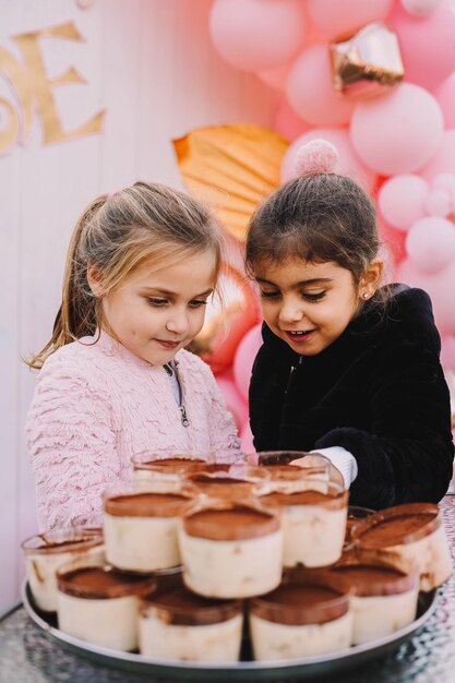 Girls in front of a tray full of individual tiramisu desserts