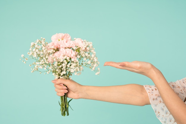 Photo girls hand holding spring bouquet, other hand with open palm holds your product