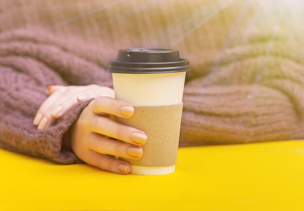コーヒーカップの上面図を保持している女の子の手