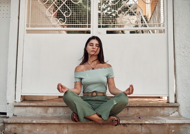 Girls is sitting in tranquility pose on the street