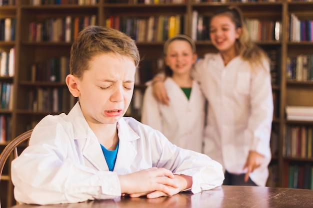 Photo girls laughing at crying bullied little boy