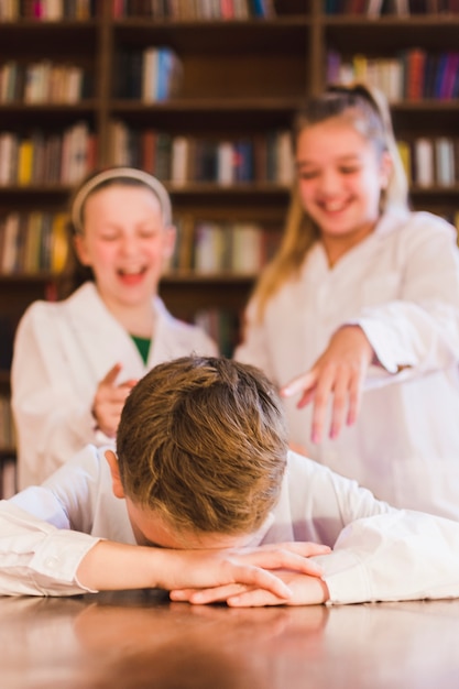 Photo girls laughing at upset little boy