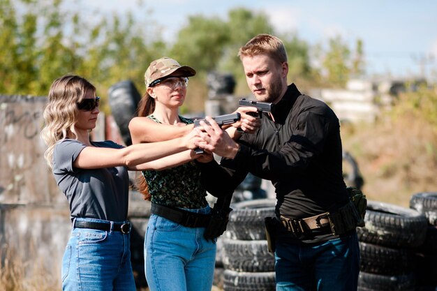 Girls learn to shoot pistols at targets at a shooting range with an instructor