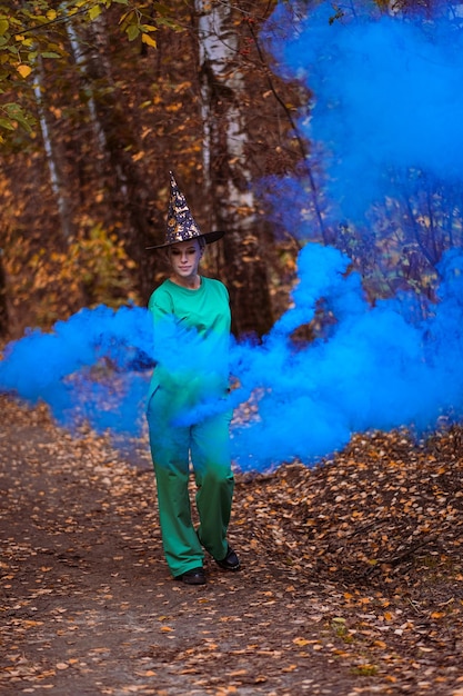 Girls in a magic forest with colored smoke