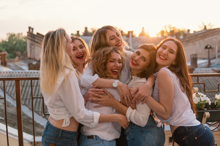 걸스 파티. 일몰 동안 Bachelorette Party의 발코니 또는 지붕에서 아름다운 여성 우정. 그들은 포옹