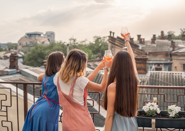 ガールズパーティー。女性はバルコニーに立って、シャンパンを飲みながら見ています