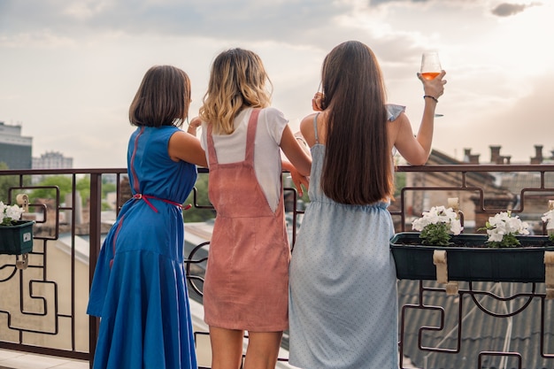 Festa delle ragazze. le donne sono in piedi sul balcone e guardano, bevendo champagne