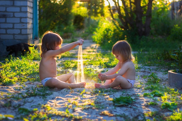 Girls play with sand in the yard