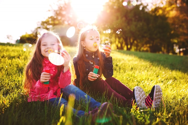 Girls play with soap bubbles.