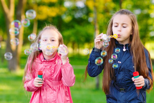 Girls play with soap bubbles.