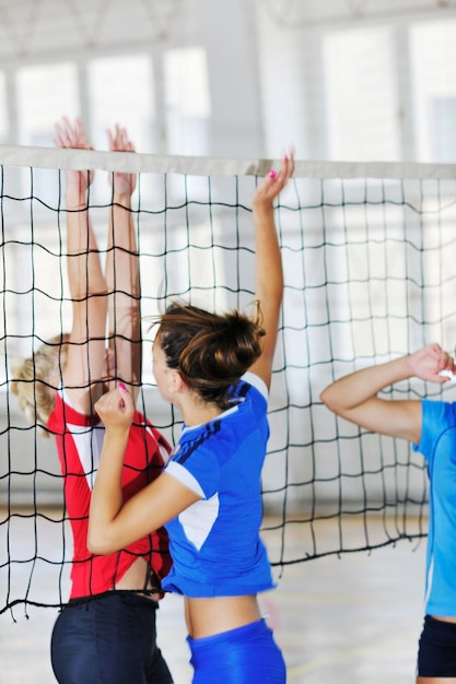Фото Девочки играют в волейбол в помещении.