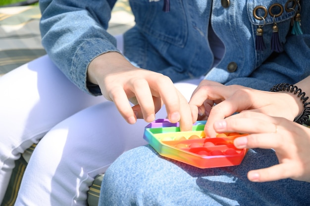 Girls playing with popular silicone antistress pop it hexagon toy