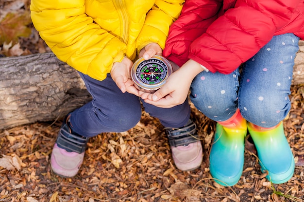 Foto ragazze toddler tenendo la bussola nelle mani. bambini che esplorano la natura nella foresta