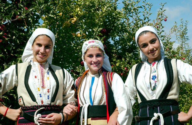 Photo girls in traditioal macedonian clothes posing in apple orchardmacedonia 2016 editorial use only