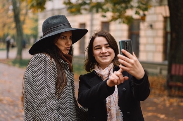 Girls using phone for video call to friends in the park