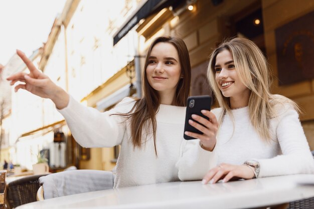 girls using a smartphone at a cafeteria table