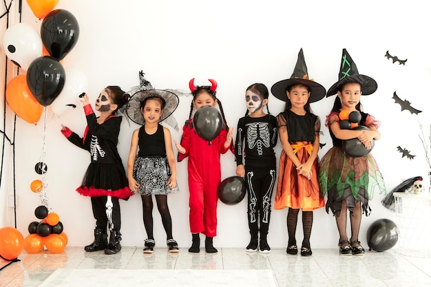 Foto ragazze in vari costumi in piedi contro il muro durante halloween