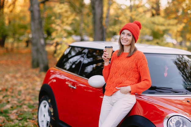 Girls walking in autumn park in red car autumn mood concept