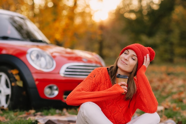 Girls walking in autumn park in red car autumn mood concept