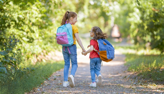 バックパックを持った女の子は学校に行きます